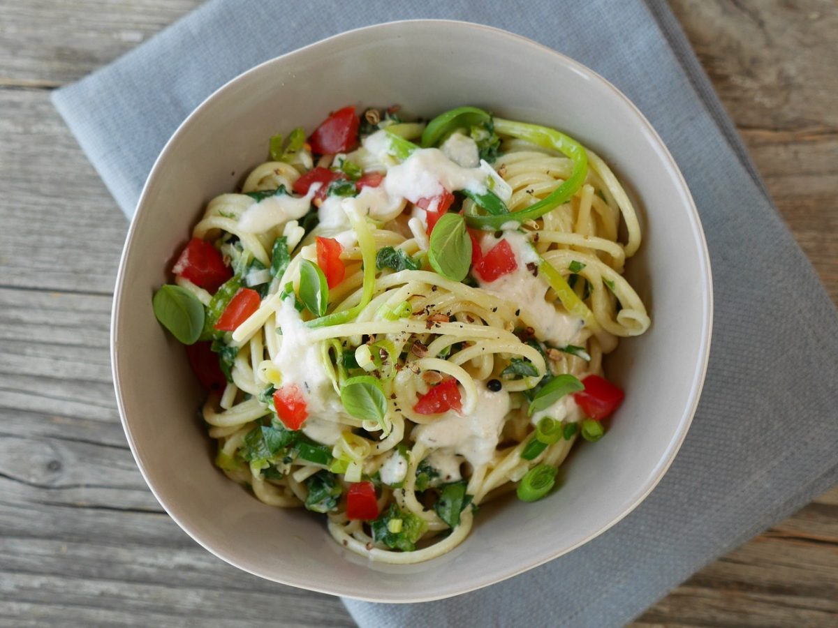 Spagetthi mit Parmesan-Soße in weisser Schüssel